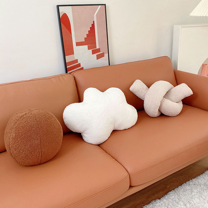 Coussin en peluche à forme géométrique avec boule et corde nouée